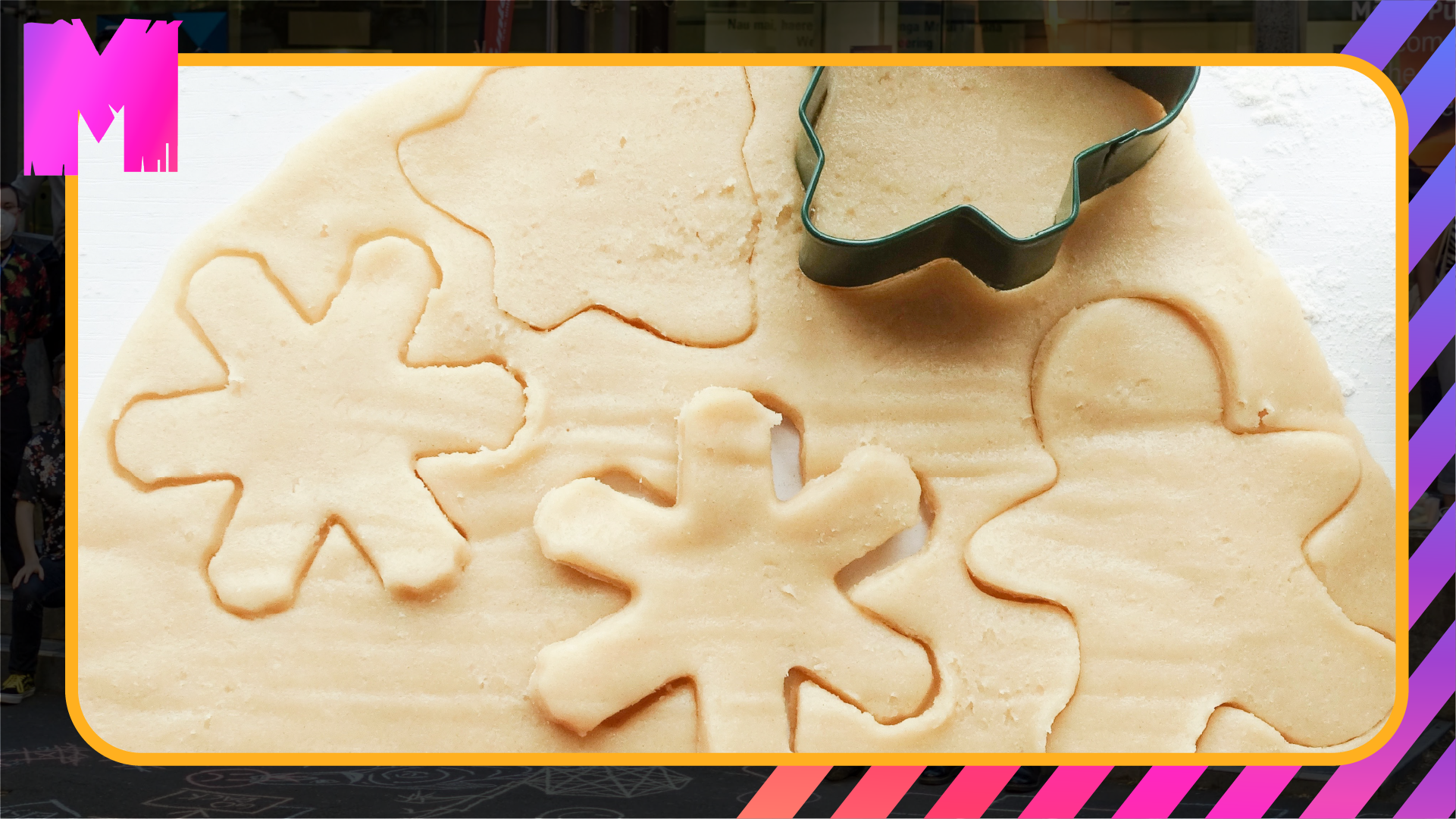 some cookies being cut from a sheet of cookie dough